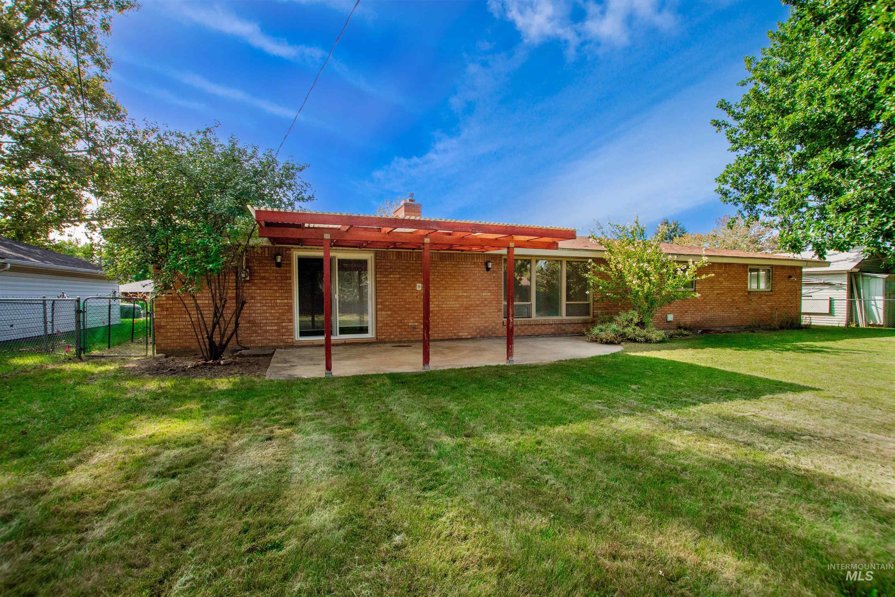 2716 North Redway Road Boise, ID 83704 - Photo 34 of 36 Brick exterior with a covered patio, sliding glass door, and expansive yard