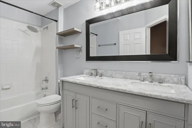 a bathroom with a granite countertop sink a toilet and a bathtub