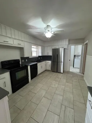a large kitchen with cabinets and stainless steel appliances