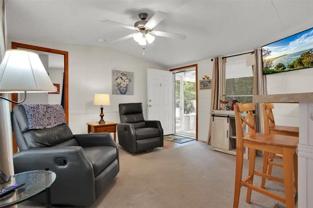 a living room with furniture a flat screen tv and a large window