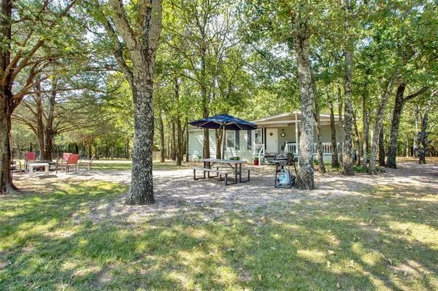 a view of a house with backyard and sitting area