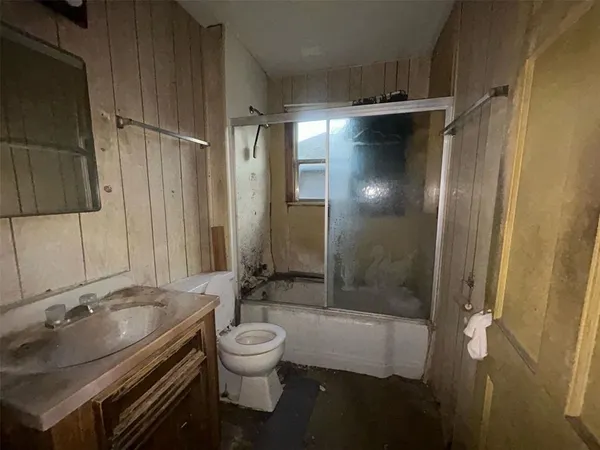 an empty room with windows and ceiling fan