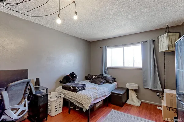 a bedroom with a bed and wooden floor