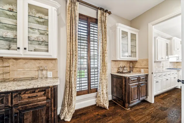 a kitchen with stainless steel appliances granite countertop a stove a sink dishwasher and a wooden cabinets with wooden floor