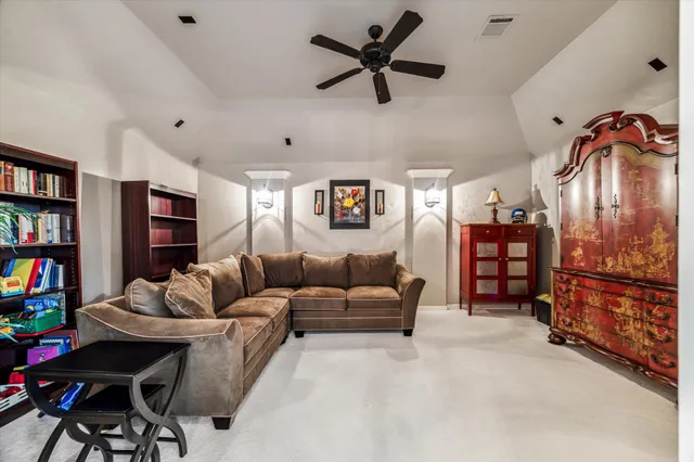 a living room with furniture and a ceiling fan