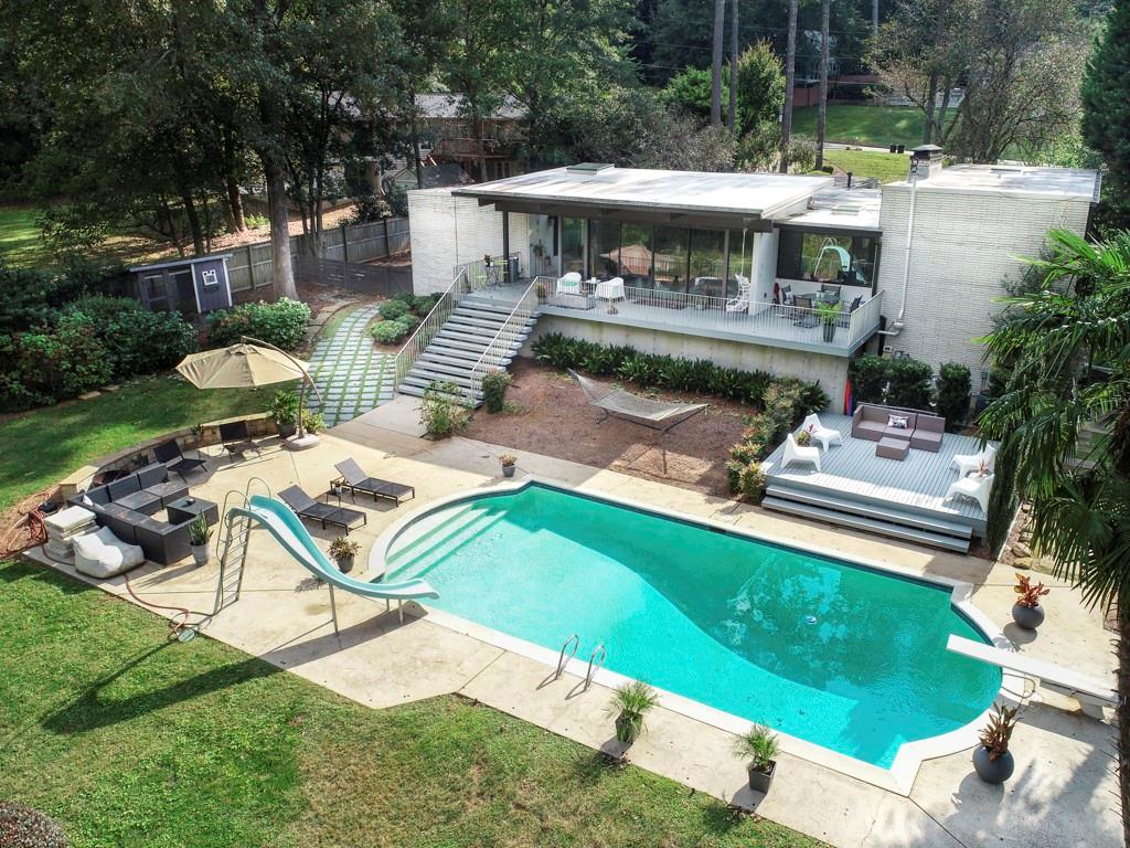 a view of a patio with table and chairs potted plants and large tree