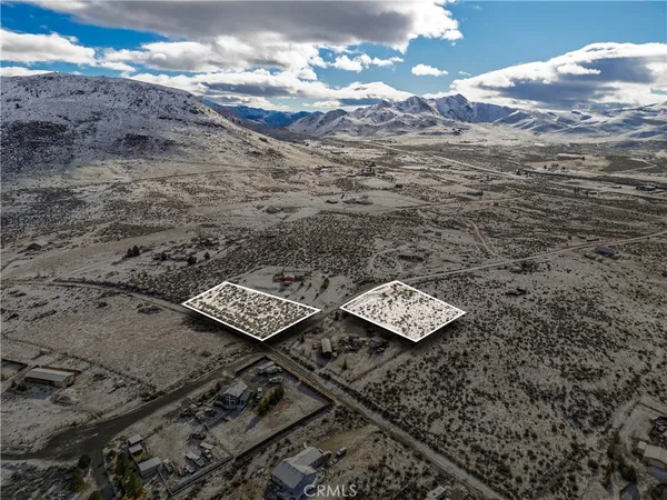 a view of a dry yard with wooden fence