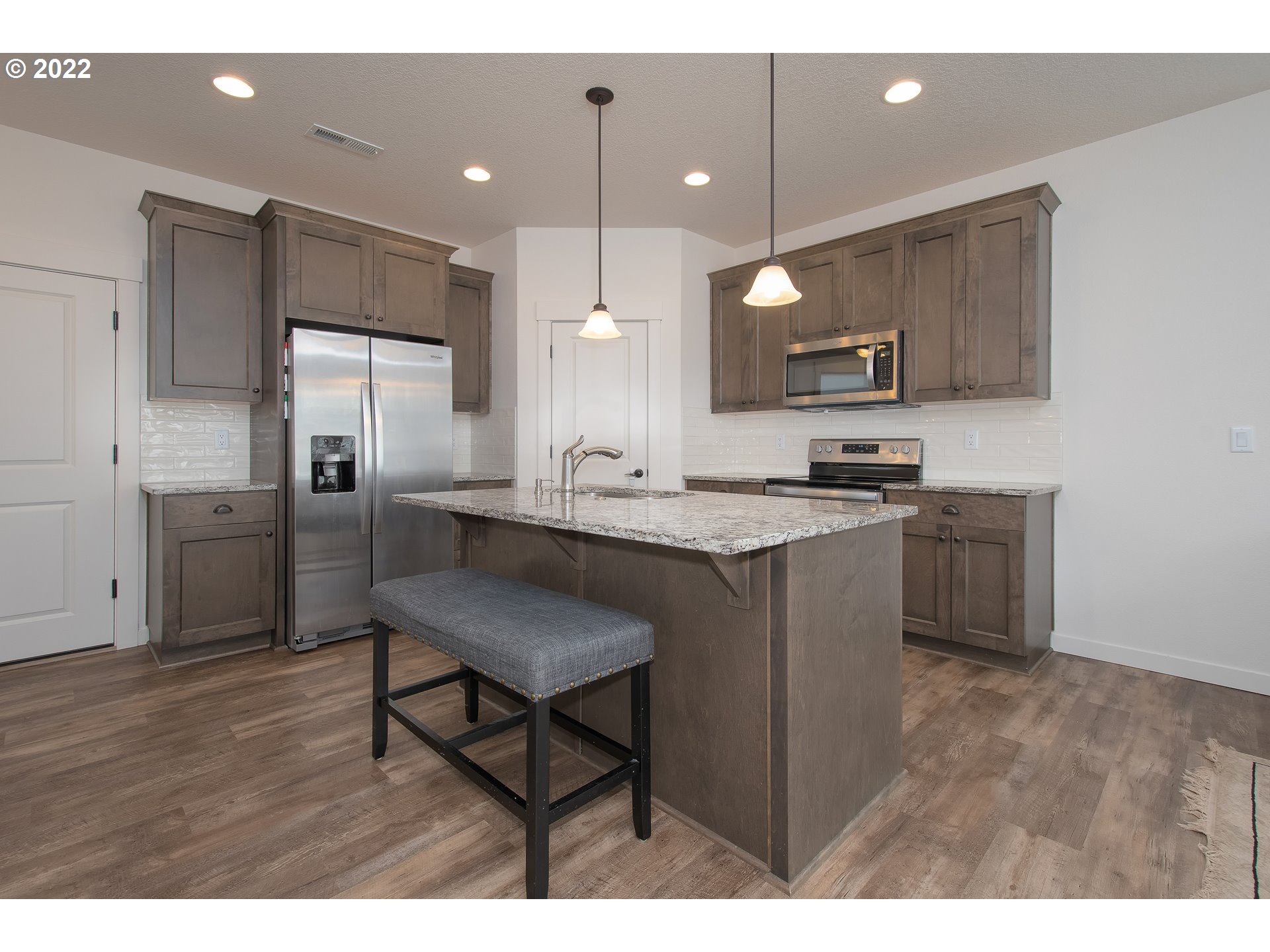 7030 South Ridge Way Ridgefield, WA 98642 - Photo 11 of 27 a kitchen with a sink cabinets and refrigerator