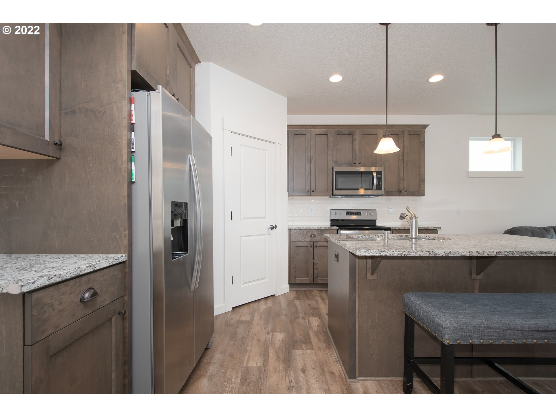 7030 South Ridge Way Ridgefield, WA 98642 - Photo 12 of 27 a kitchen with a sink a refrigerator a stove and cabinets