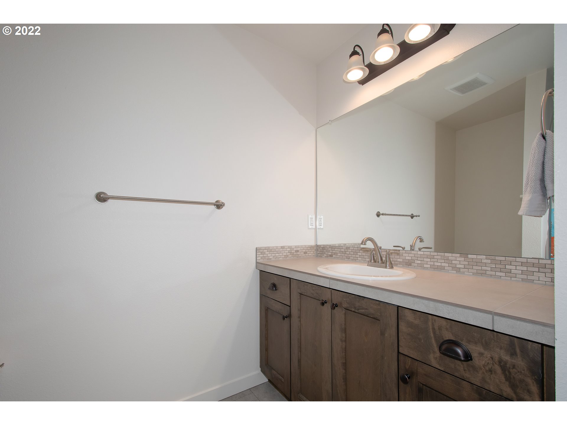 7030 South Ridge Way Ridgefield, WA 98642 - Photo 23 of 27 a bathroom with a granite countertop sink and a mirror
