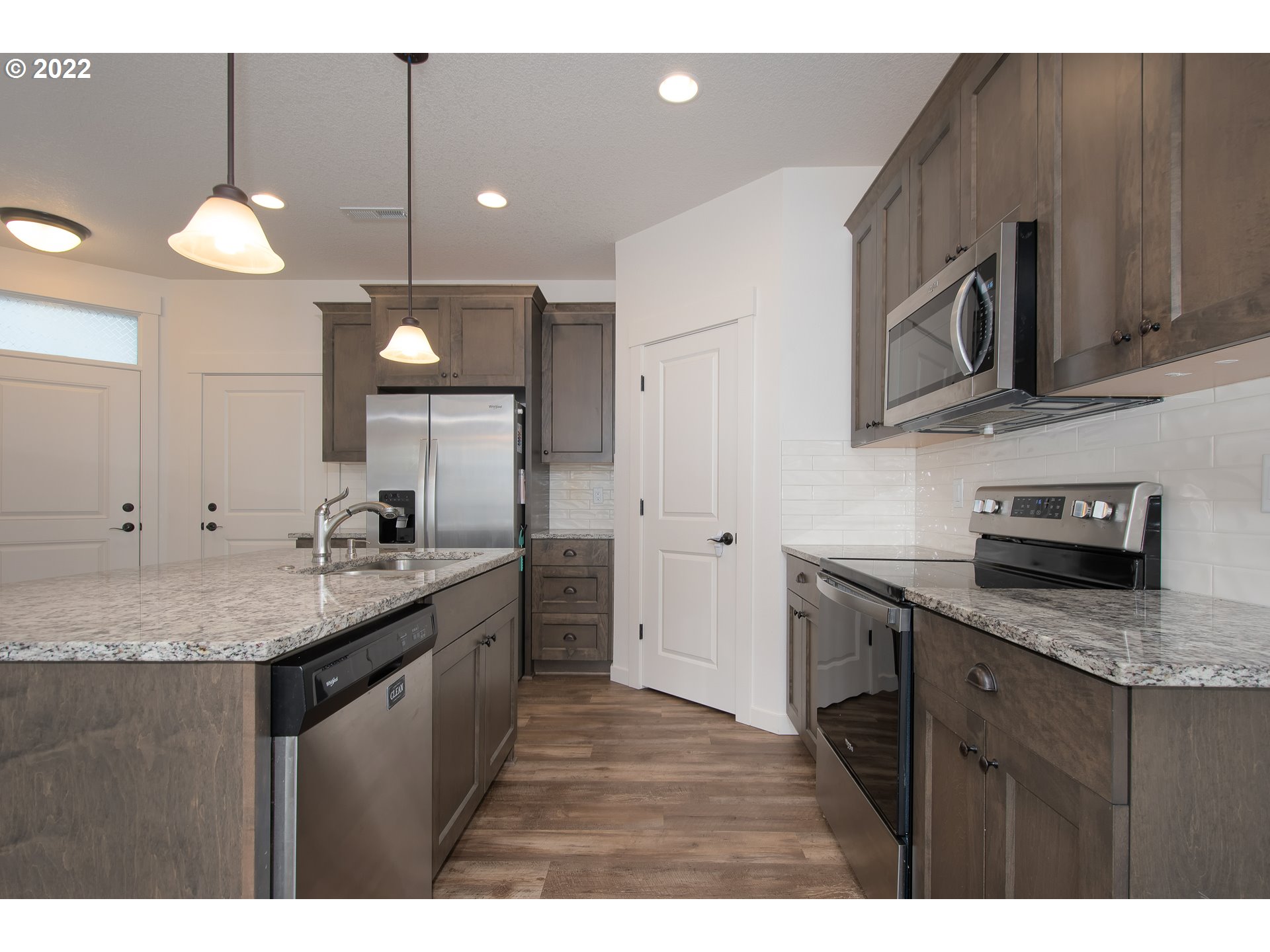 7030 South Ridge Way Ridgefield, WA 98642 - Photo 9 of 27 a kitchen with stainless steel appliances granite countertop a sink a stove and a microwave