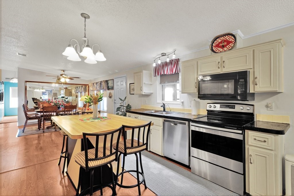 7605 Cedar Bark Road Sebastian, FL 32976 - Photo 12 of 34 a kitchen with stainless steel appliances granite countertop a sink a stove a dining table and chairs