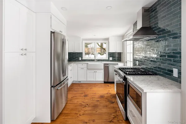 a kitchen with granite countertop a refrigerator and a stove top oven