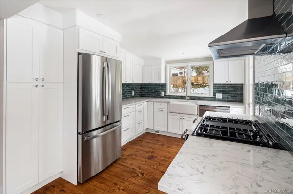 a kitchen that has a stove and a wooden floor