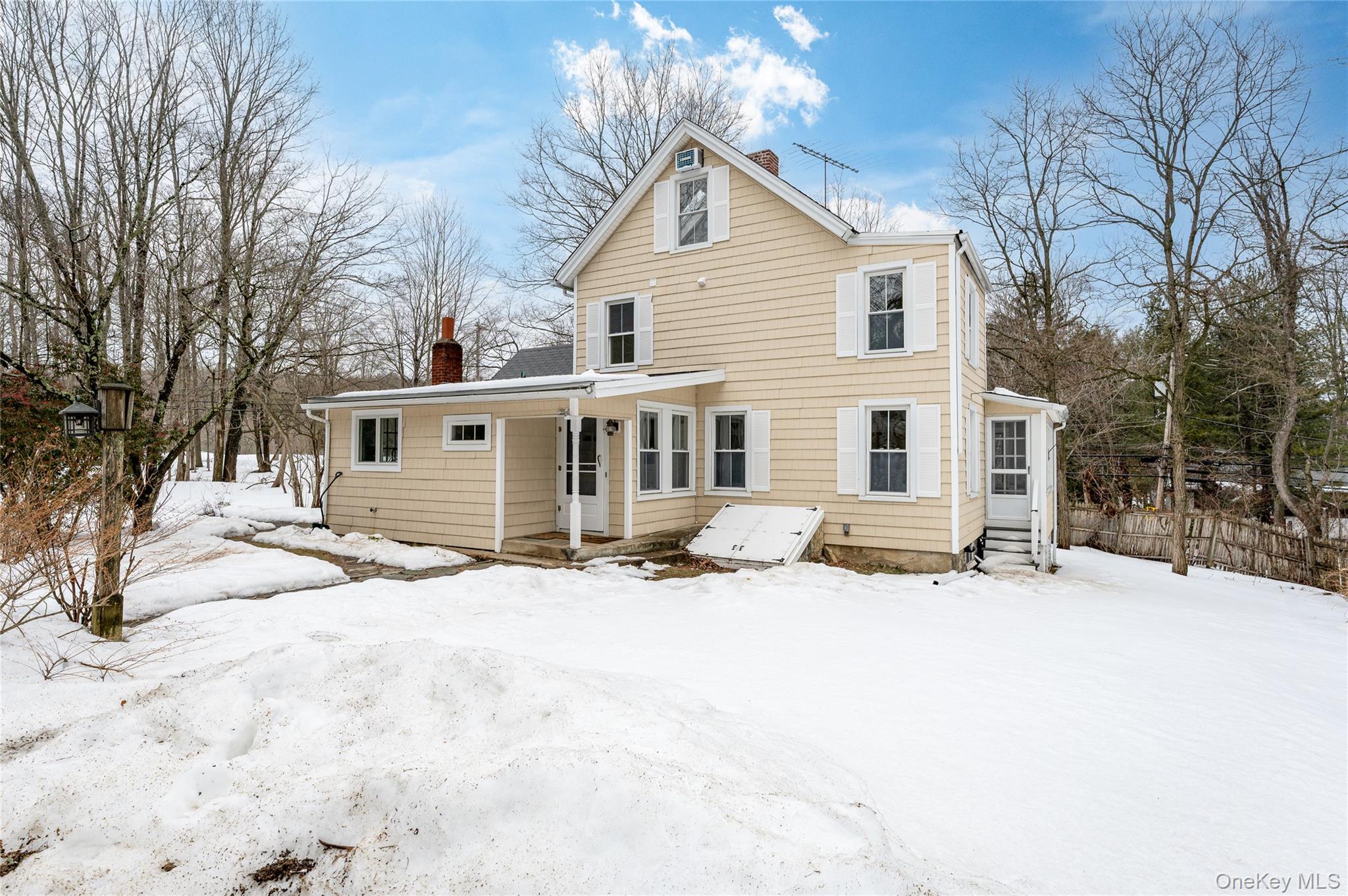 277 Old Post Road Bedford, NY 10506 - Photo 6 of 39 a front view of a house with a yard covered in snow