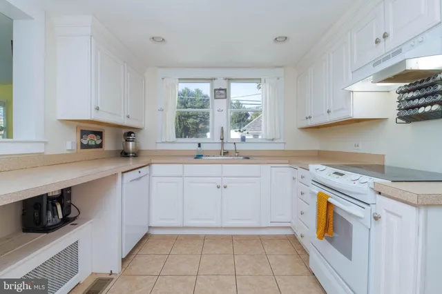 a kitchen with white cabinets and appliances