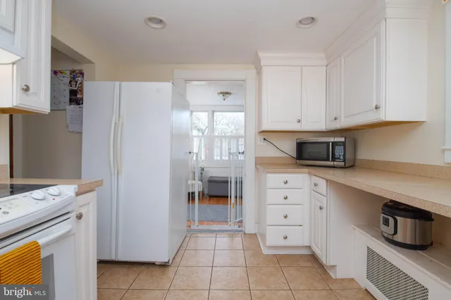 a kitchen with white cabinets and appliances