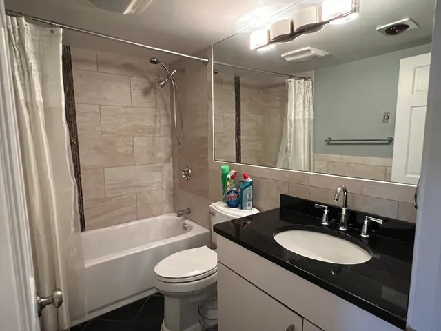 a bathroom with a granite countertop sink toilet and shower