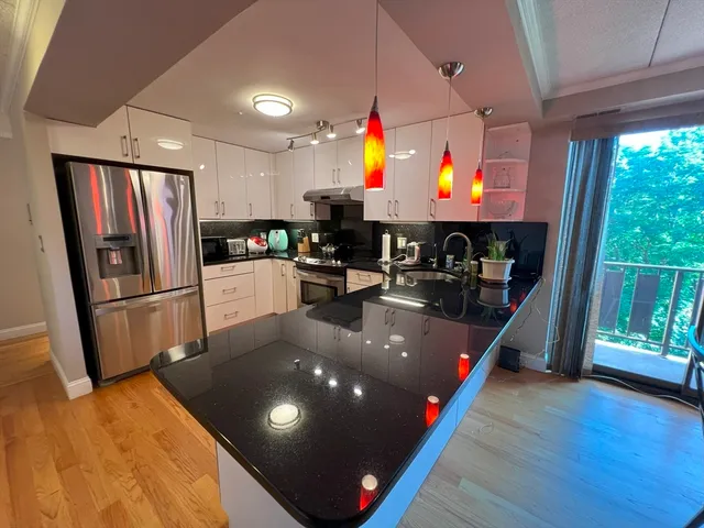 a kitchen with stainless steel appliances granite countertop a sink a stove and a refrigerator