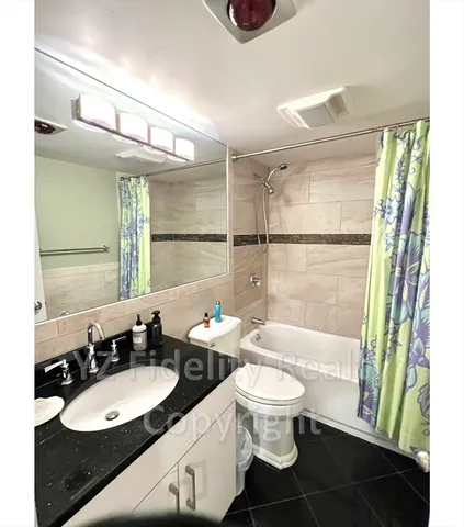 a bathroom with a granite countertop sink toilet a mirror and shower