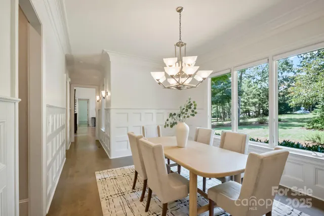 a view of a dining room with furniture a chandelier and wooden floor