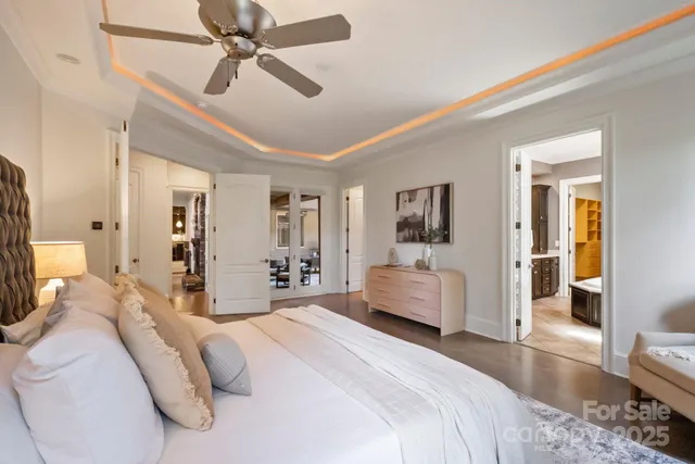 a bedroom with a large bed and ceiling fan