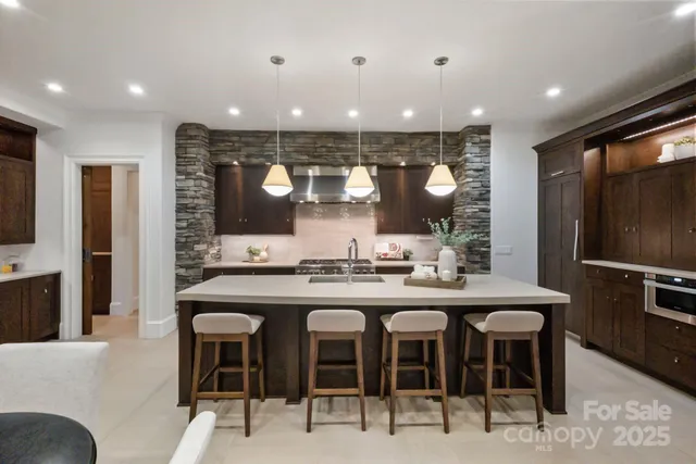 a kitchen with stainless steel appliances granite countertop a sink and a refrigerator