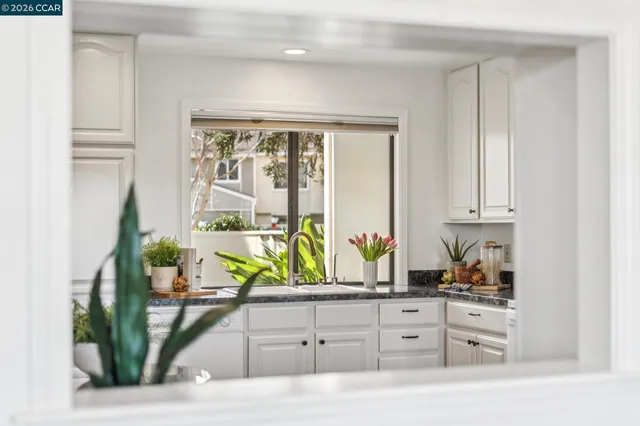 a spacious kitchen with stainless steel appliances granite countertop a table and chairs in it