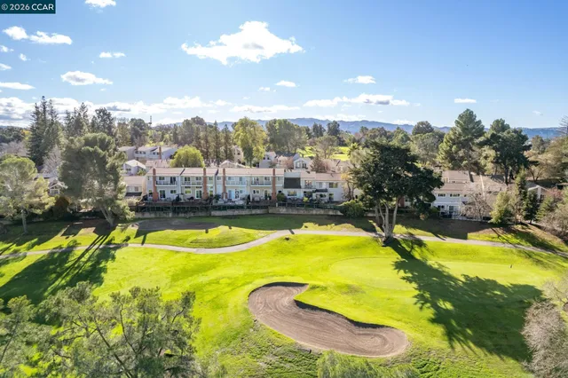 an aerial view of residential house with yard and mountain view in back