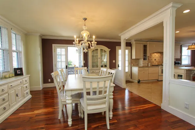 a view of a dining room with furniture a chandelier and wooden floor