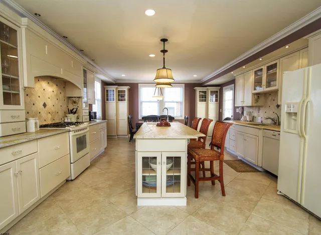 a kitchen with a stove a refrigerator and dining table