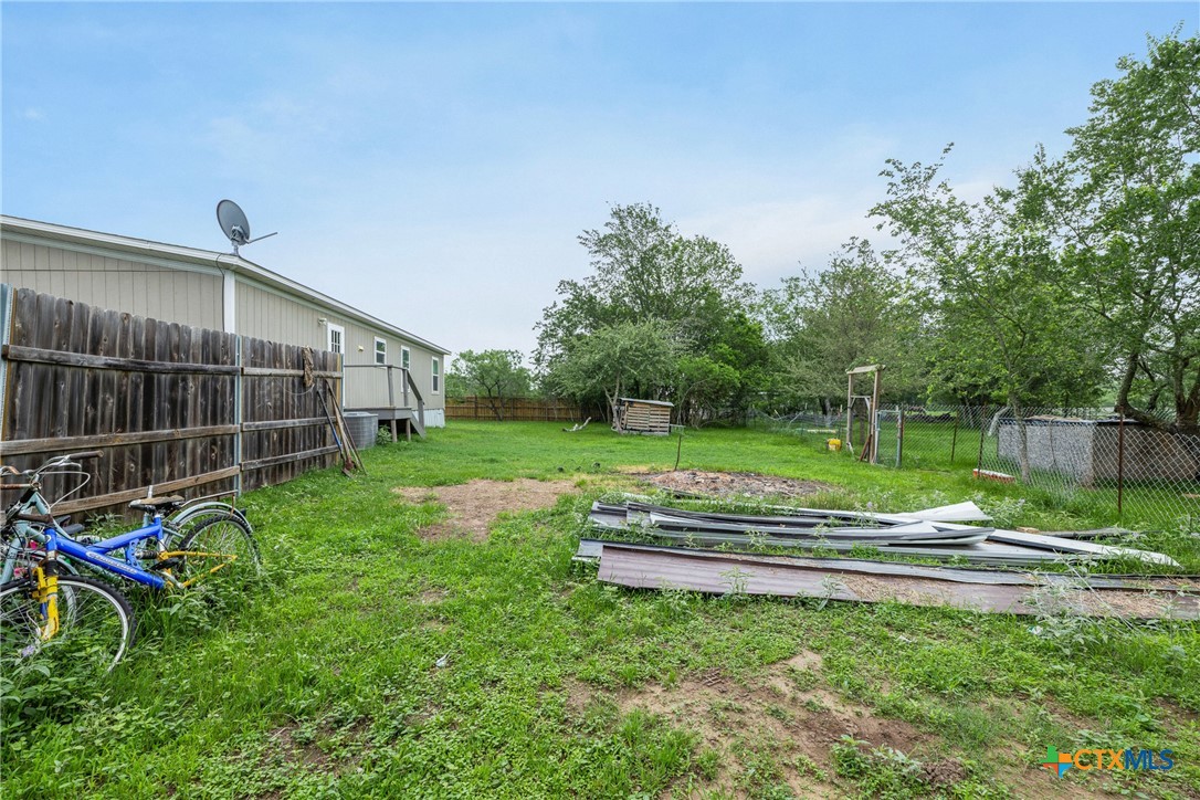 6497 Taylorsville Road Dale, TX 78616 - Photo 21 of 36 a view of backyard with wooden fence and a large trees