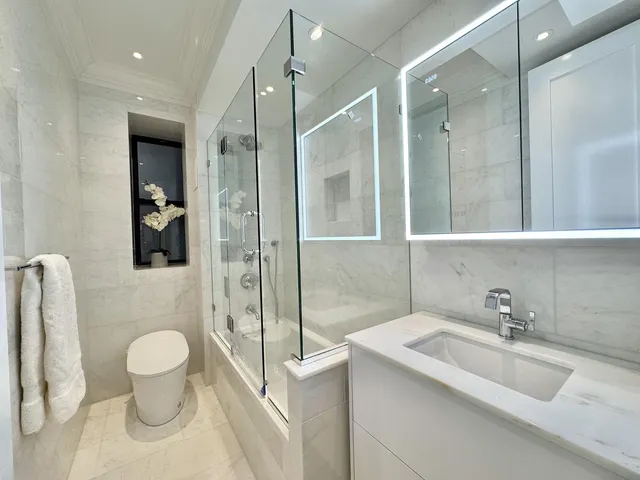 a bathroom with a sink a toilet and shower