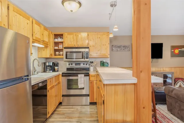a kitchen with stainless steel appliances granite countertop a stove a sink and a refrigerator