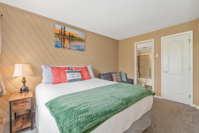 a bedroom with a bed and a painting on the wall