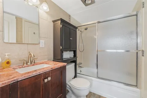a bathroom with a granite countertop sink toilet and shower