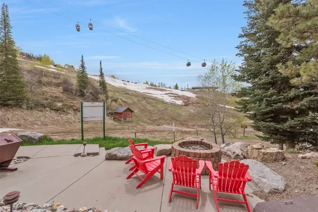 a view of a large white house with a small yard and large trees