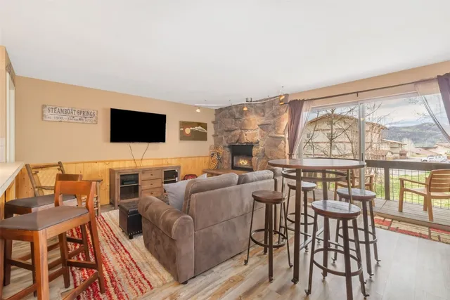 a living room with furniture a flat screen tv and a floor to ceiling window