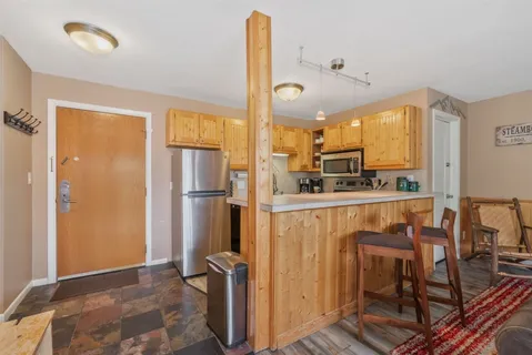 a kitchen with stainless steel appliances granite countertop a refrigerator and a stove top oven