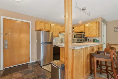 a kitchen with stainless steel appliances granite countertop a refrigerator and a stove top oven