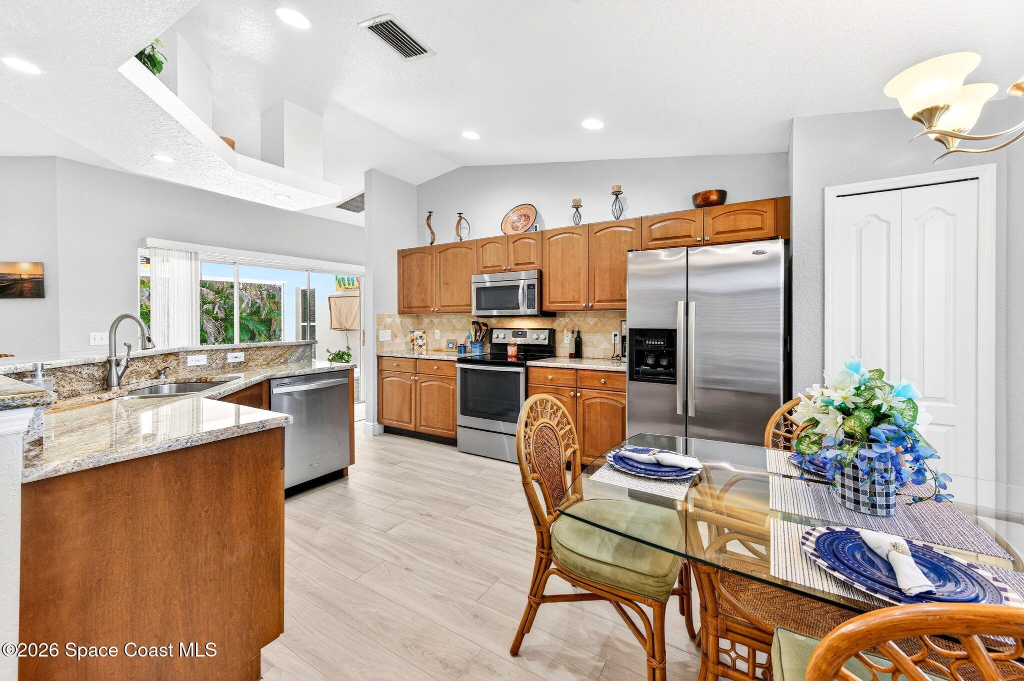 121 Ocean Ridge Drive Melbourne Beach, FL 32951 - Photo 29 of 41 a kitchen with a table chairs refrigerator and microwave