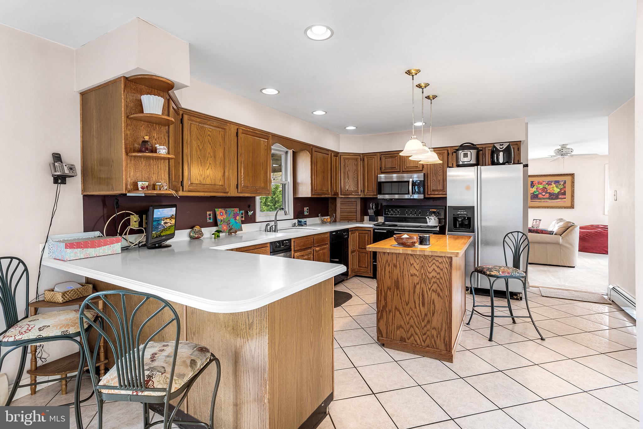200 Casperson Street Gibbstown, NJ 08027 - Photo 15 of 64 a kitchen with stainless steel appliances granite countertop a sink a stove a refrigerator cabinets and chairs