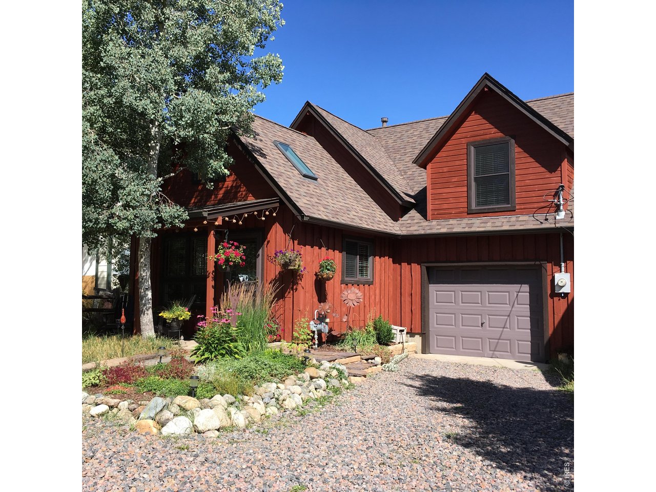 131 West Boulder Street Nederland, CO 80466 - Photo 2 of 46 Front exterior porch with Adirondack chairs, potted flowers, and welcoming entryway.