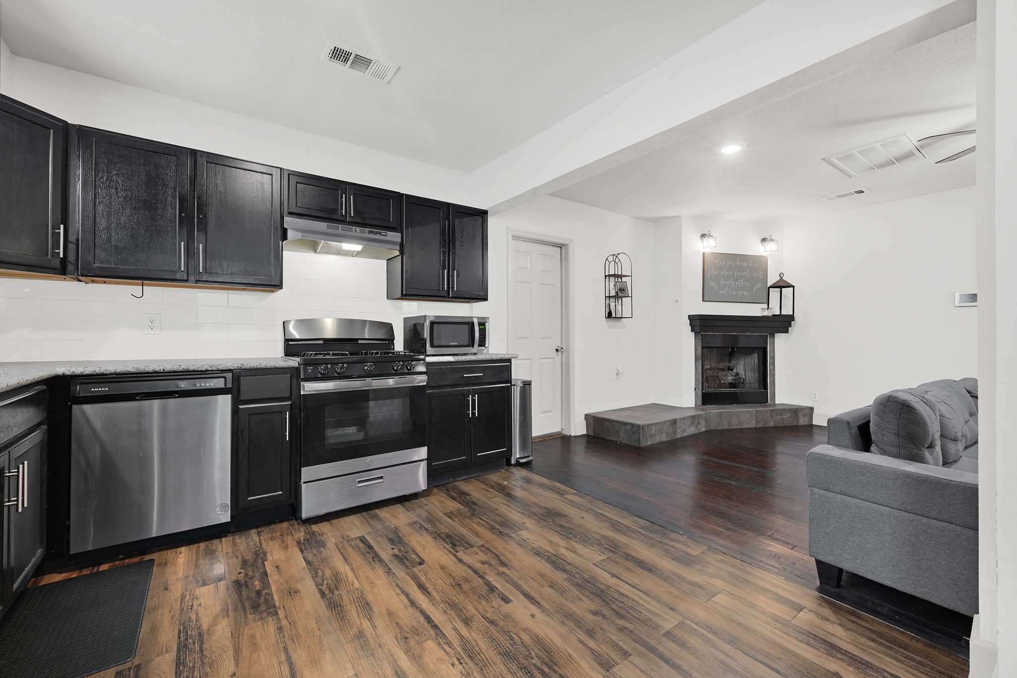 207 Wafer Street Pasadena, TX 77506 - Photo 8 of 26 a kitchen with granite countertop wooden floors and stainless steel appliances