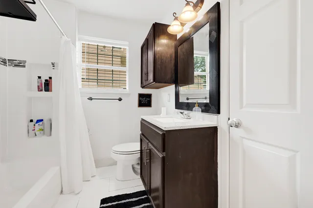a bathroom with a sink vanity mirror and toilet