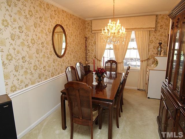 5522 Earl Road Durham, NC 27712 - Photo 4 of 13 a dining room with furniture a rug a potted plant and a chandelier