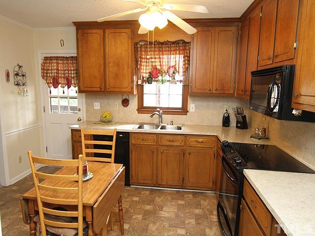 5522 Earl Road Durham, NC 27712 - Photo 5 of 13 a kitchen with granite countertop a sink stove and cabinets