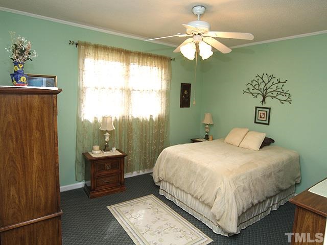 5522 Earl Road Durham, NC 27712 - Photo 8 of 13 a bedroom with a bed chandelier and a window