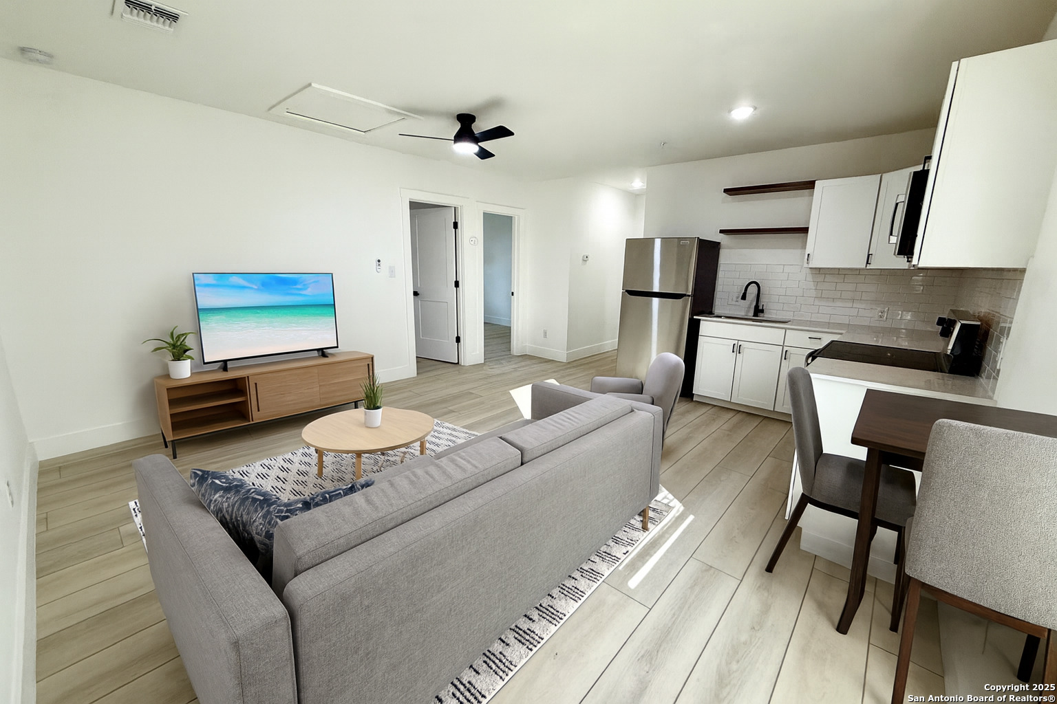 a living room with furniture and a wooden floor