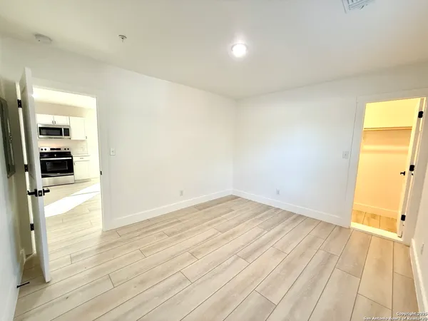 a view of empty room with wooden floor